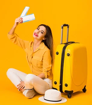 Smiling woman with suitcase and flight tickets